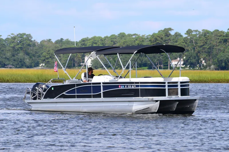 Slide: The Image of 2022 Barletta Corsa 25U pontoon boat cruising on a scenic lake. - 5
