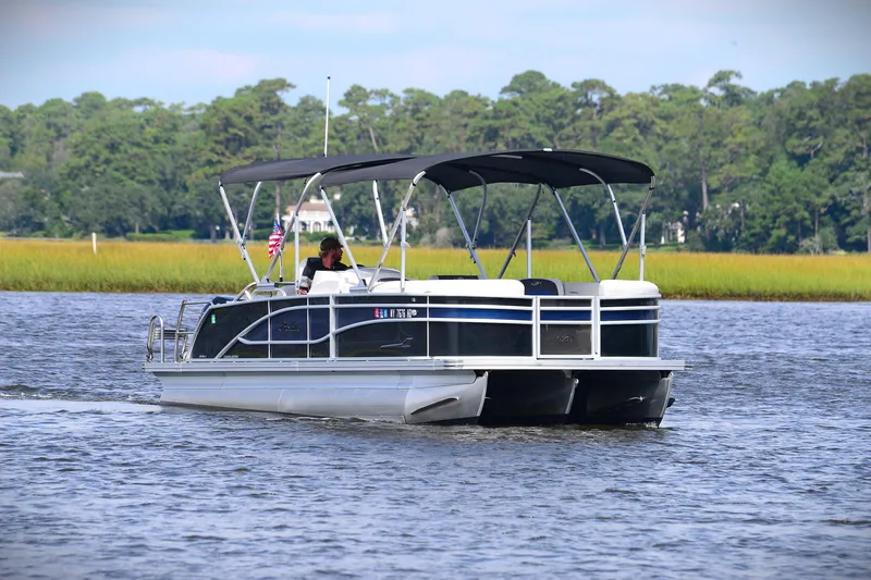 Slide: The Image of 2022 Barletta Corsa 25U pontoon boat cruising on a scenic lake. - 6