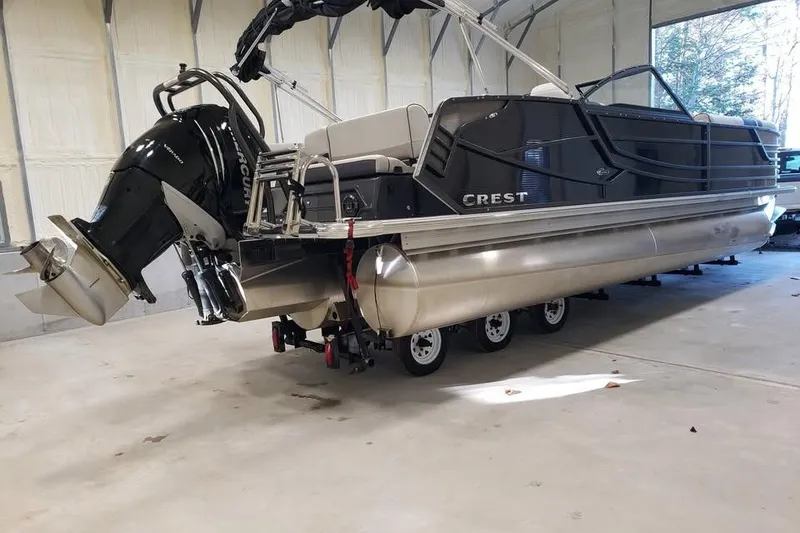Slide: The Image of 2021 Crest Continental 250 SLS pontoon boat in a garage, featuring a powerful outboard motor. - 6