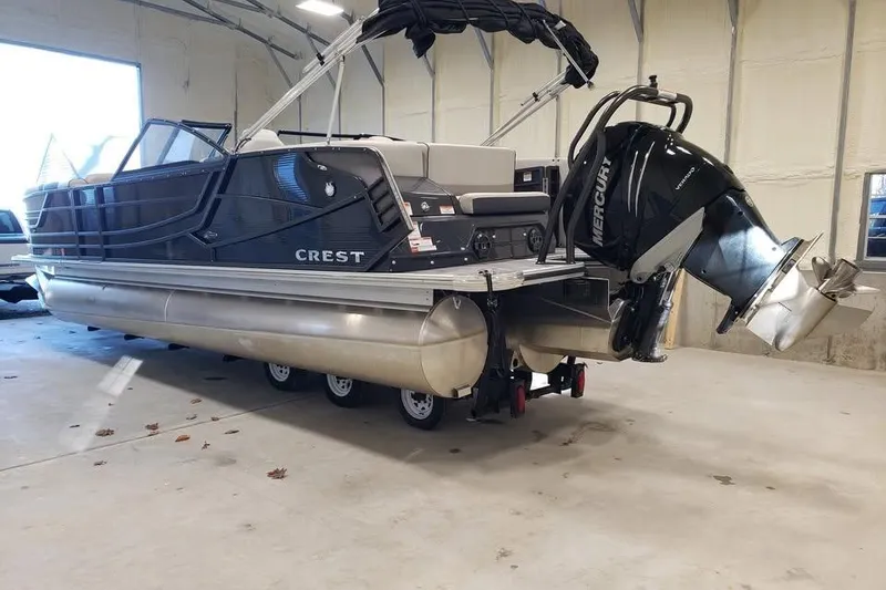 Slide: The Image of 2021 Crest Continental 250 SLS pontoon boat with Mercury outboard in indoor storage. - 7