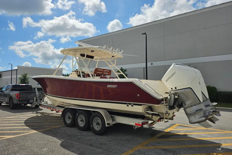 The Image of 2012 Pursuit C 310 Center Console boat on trailer, parked outdoors. - 0