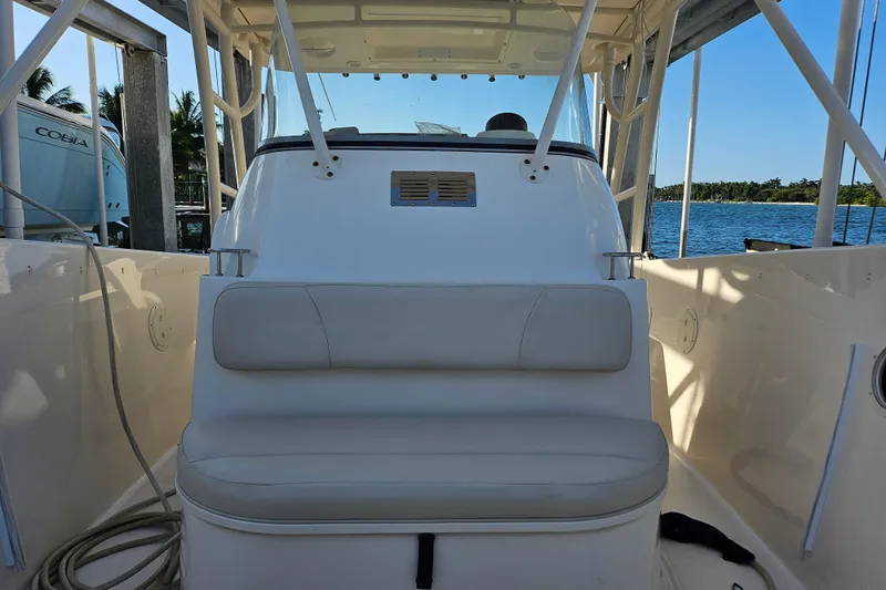 Slide: The Image of 2012 Pursuit C 310 Center Console boat interior with seating, docked by the water. - 11