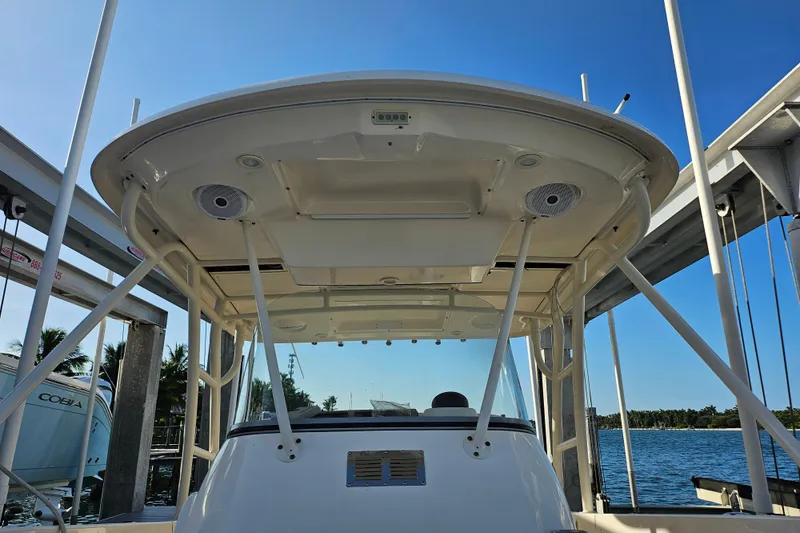 Slide: The Image of 2012 Pursuit C 310 Center Console boat with T-top, docked by the water. - 12