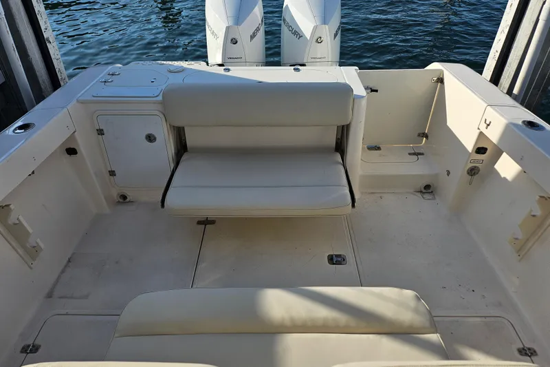 Slide: The Image of 2012 Pursuit C 310 Center Console boat interior with seating and twin Mercury engines. - 14