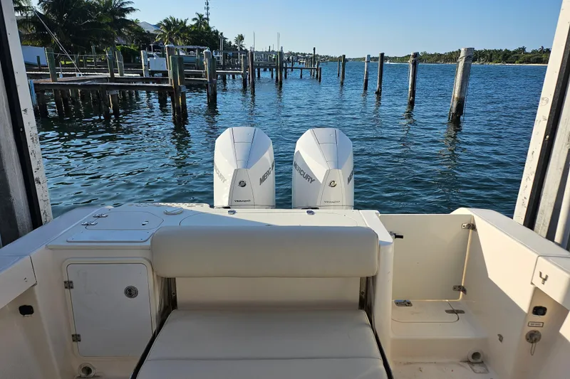 Slide: The Image of 2012 Pursuit C 310 Center Console boat with twin Mercury engines docked by the water. - 15