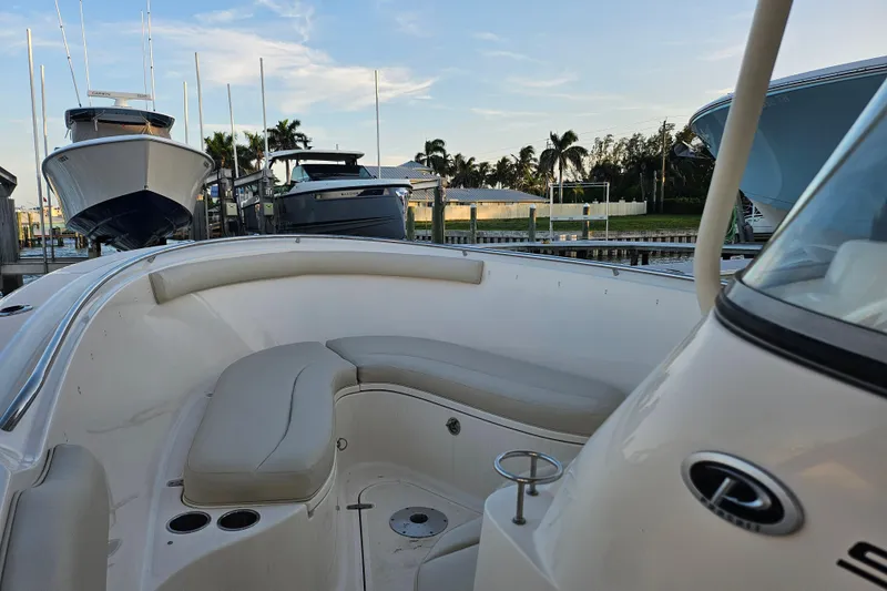 Slide: The Image of 2012 Pursuit C 310 Center Console boat docked with cushioned seating area. - 23