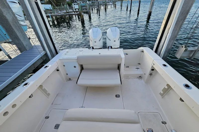 Slide: The Image of 2012 Pursuit C 310 Center Console boat with dual engines, docked by the water. - 24