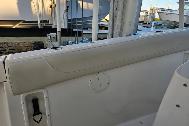 Slide: The Image of 2012 Pursuit C 310 Center Console boat interior with cushioned seating and cup holders. - 25