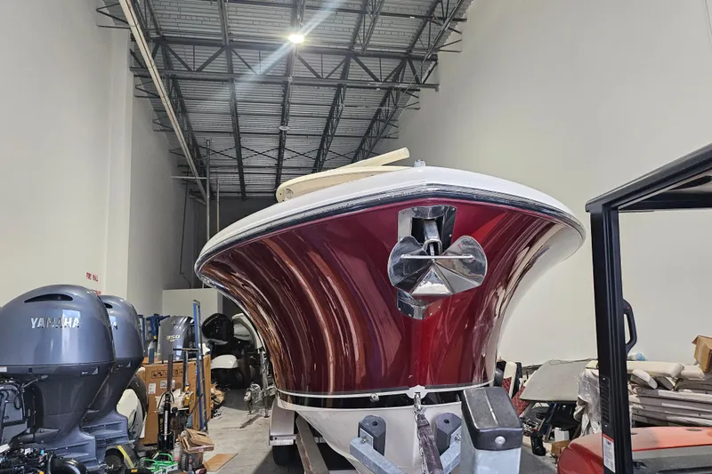 Slide: The Image of 2012 Pursuit C 310 Center Console boat in storage, featuring a red hull and Yamaha engines. - 28
