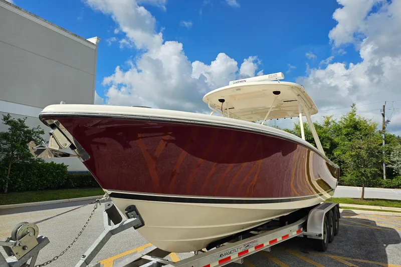 Slide: The Image of 2012 Pursuit C 310 Center Console boat on trailer under blue sky. - 32