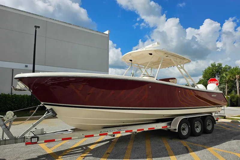 Slide: The Image of 2012 Pursuit C 310 Center Console boat on trailer, parked outdoors. - 33