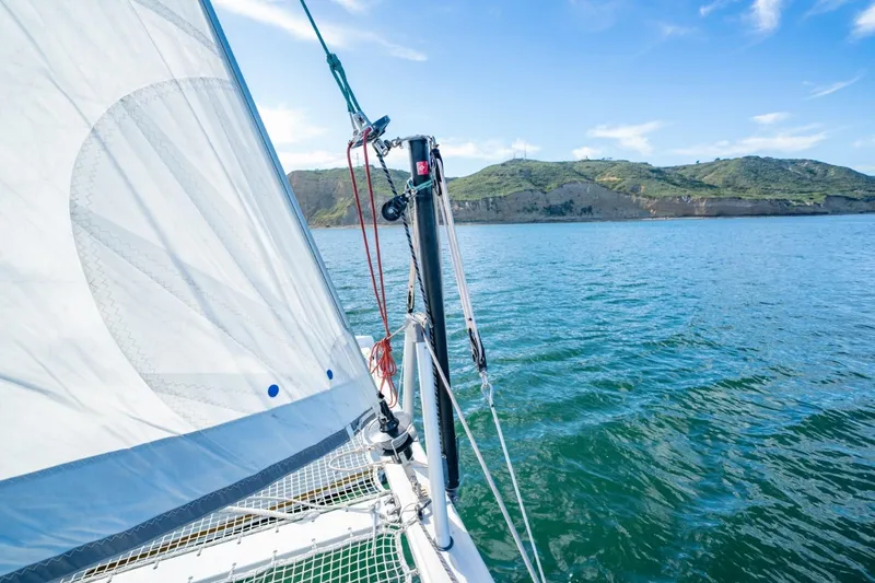 Slide: The Image of Sailing on a 2020 Nautitech 40 Open catamaran with scenic coastal views. - 13