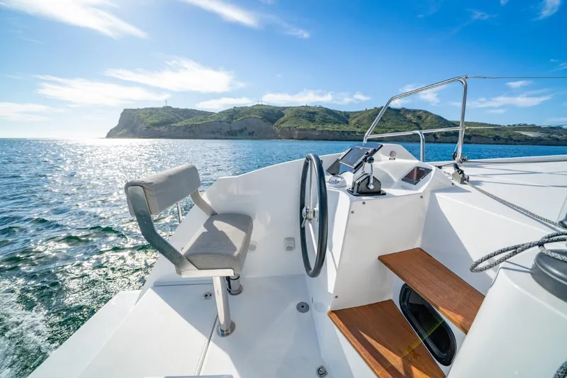 Slide: The Image of Cockpit view of 2020 Nautitech 40 Open catamaran sailing near scenic coastline. - 5
