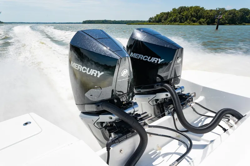 Slide: The Image of 2024 Beneteau Flyer 10 with dual Mercury outboard engines on a lake. - 17