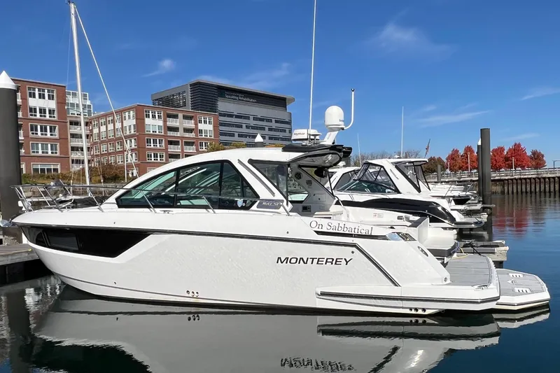 The Image of 2018 Monterey 360 Sport Coupe docked at marina, modern buildings in background. - 0