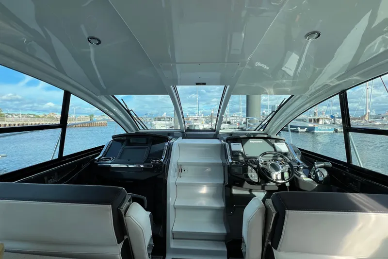 Slide: The Image of Interior view of 2018 Monterey 360 Sport Coupe yacht with modern helm and marina backdrop. - 8