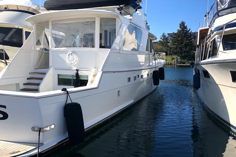 Slide: The Image of 1977 Hatteras 58 Yacht Fisherman docked between boats on a sunny day. - 2