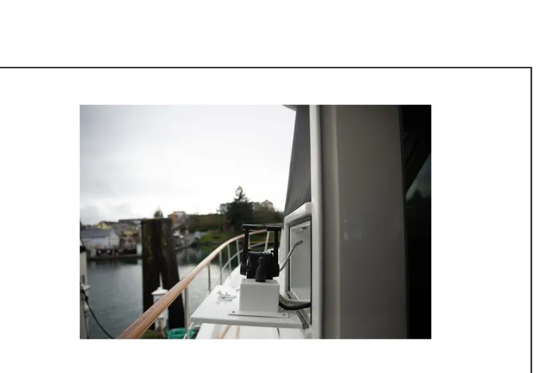 Slide: The Image of 1977 Hatteras 58 Yacht Fisherman docked, showcasing deck details and marina view. - 22