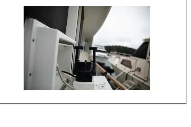 Slide: The Image of Close-up of a 1977 Hatteras 58 Yacht Fisherman deck equipment with boats in the background. - 23