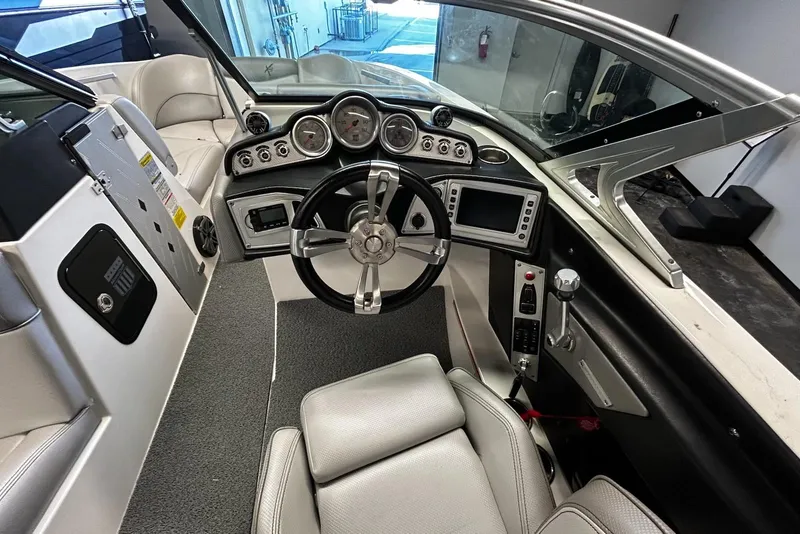Slide: The Image of 2016 MasterCraft X23 boat cockpit with steering wheel and control panel. - 8