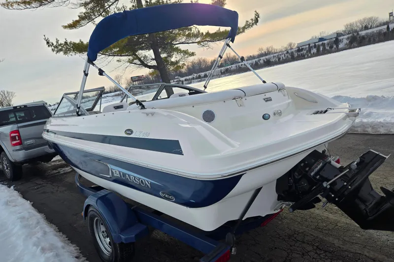 Slide: The Image of 2011 Larson LX 850 boat on trailer near snowy lake, winter setting. - 1