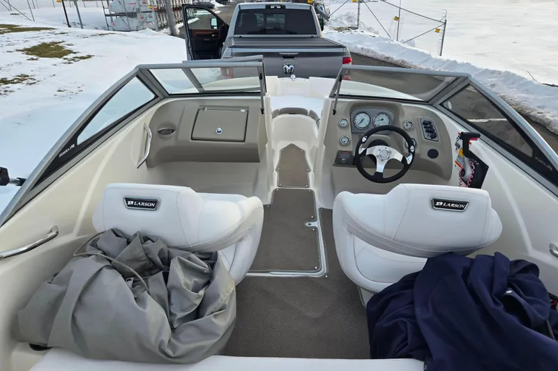 Slide: The Image of Interior of a 2011 Larson LX 850 boat with white seating and dashboard controls. - 10