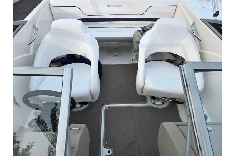 Slide: The Image of Interior of a 2011 Larson LX 850 boat with white seating and steering wheel. - 19