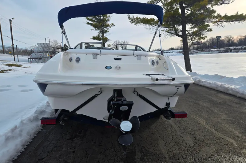 Slide: The Image of Rear view of a 2011 Larson LX 850 boat on a snowy lakeside road. - 2
