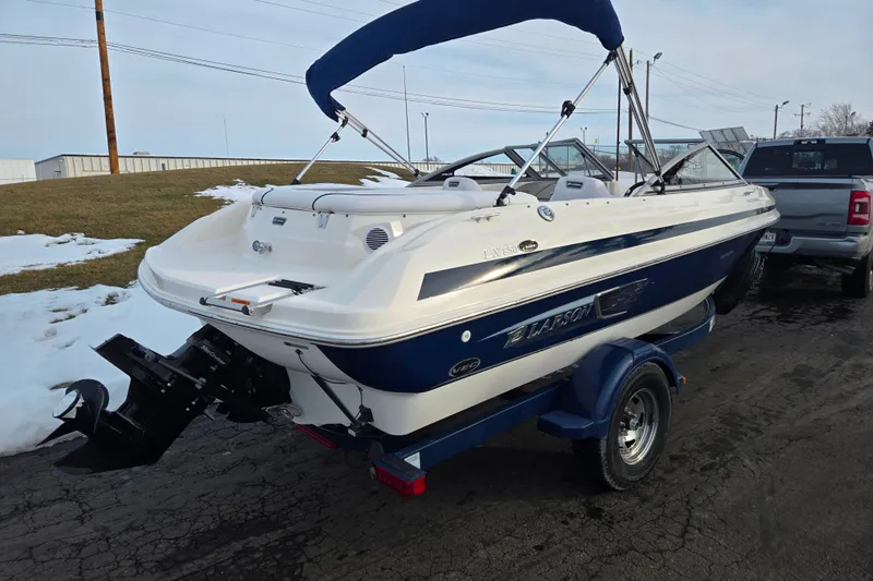Slide: The Image of 2011 Larson LX 850 boat on trailer, parked on snowy pavement. - 3