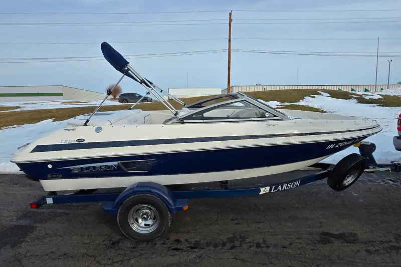 Slide: The Image of 2011 Larson LX 850 boat on trailer, parked outdoors in snowy setting. - 4