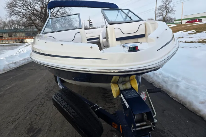 Slide: The Image of 2011 Larson LX 850 boat on trailer, parked on snowy pavement. - 6