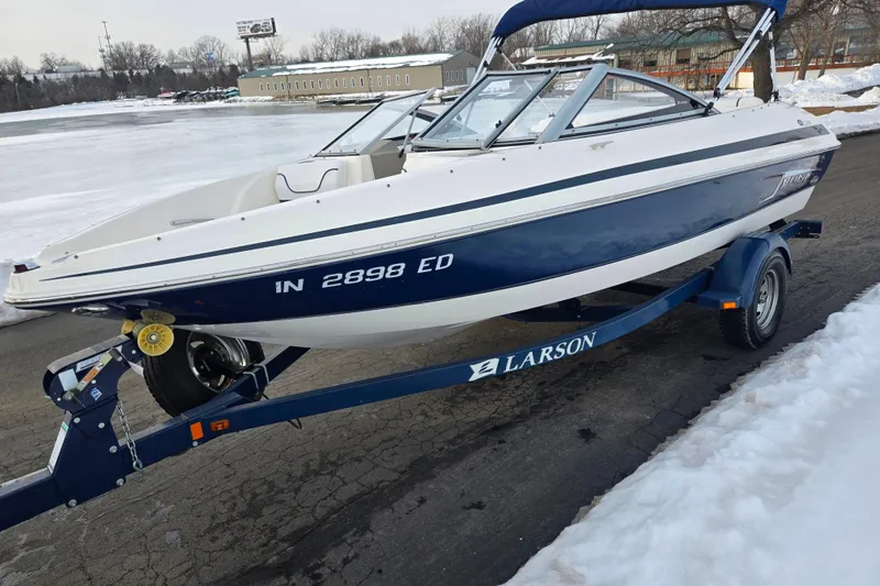 Slide: The Image of 2011 Larson LX 850 boat on trailer, parked on snowy pavement. - 8