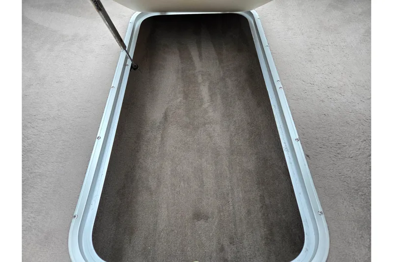 Slide: The Image of Open storage compartment in 2008 Stingray 195 LS/LX/LR boat, featuring carpeted interior. - 12