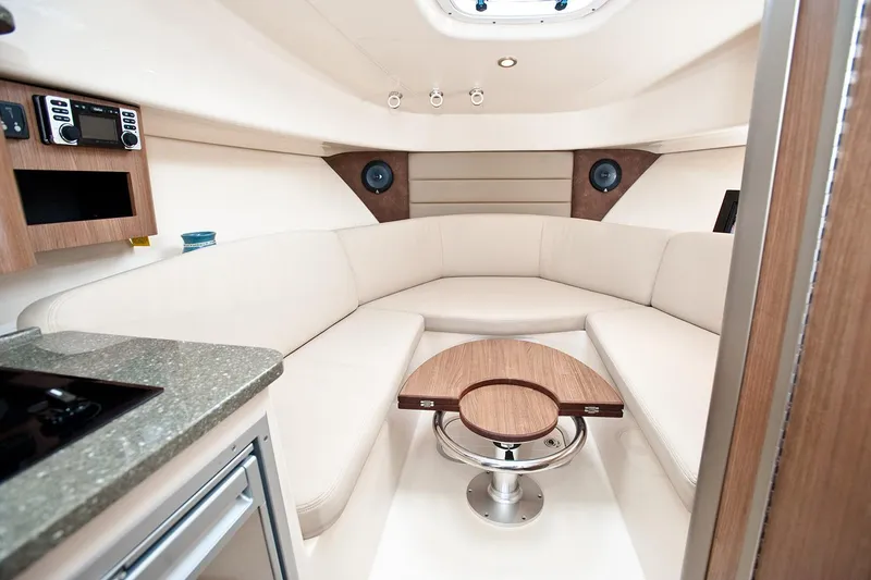 Slide: The Image of Manufacturer Provided Image: 2026 Boston Whaler 285 Conquest cabin interior with modern seating and compact table. - 4