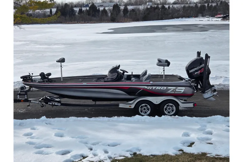 The Image of 2013 Nitro Z-9 boat on trailer by snowy lake, featuring Mercury Pro XS engine. - 0