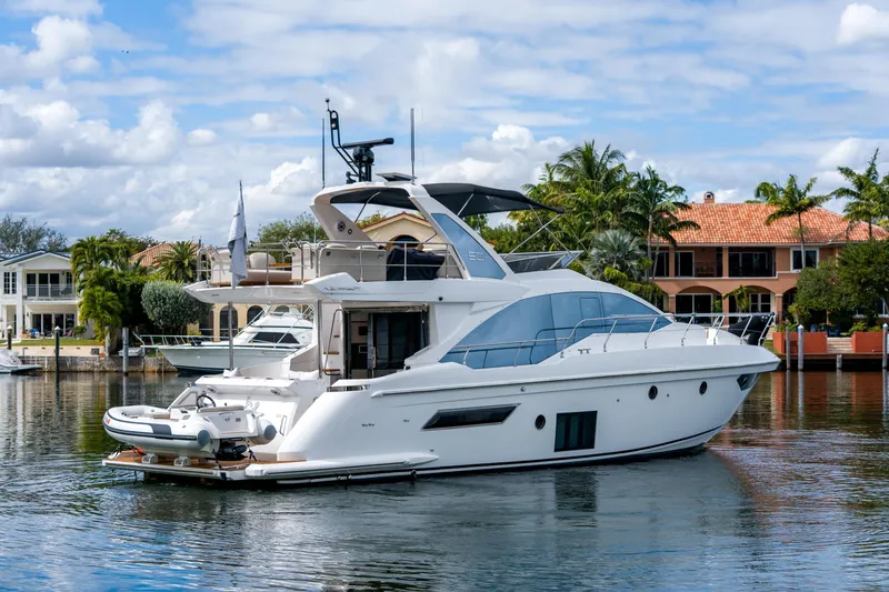 Slide: The Image of 2019 Azimut Fly 50 yacht docked in a scenic waterfront setting. - 2
