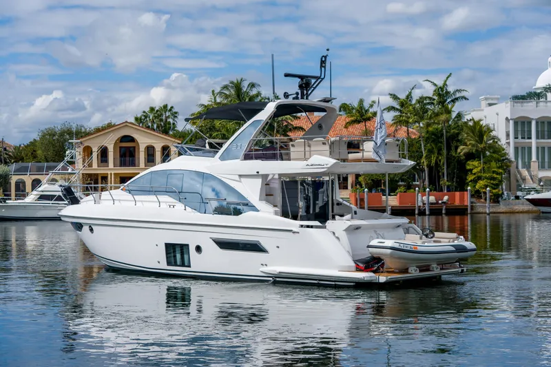 Slide: The Image of 2019 Azimut Fly 50 yacht docked in a scenic marina with luxury homes. - 3