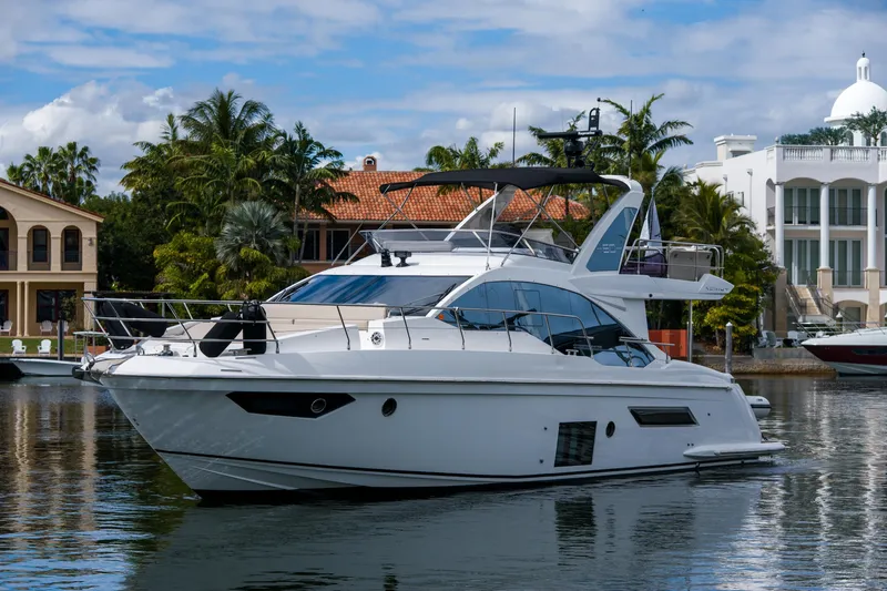 Slide: The Image of 2019 Azimut Fly 50 yacht docked near luxury waterfront homes. - 39