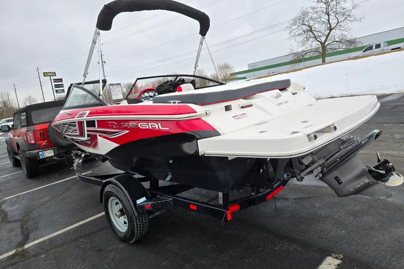 Slide: The Image of 2017 Regal 1900 ESX Bowrider on trailer, red and white design, parked in snowy lot. - 3