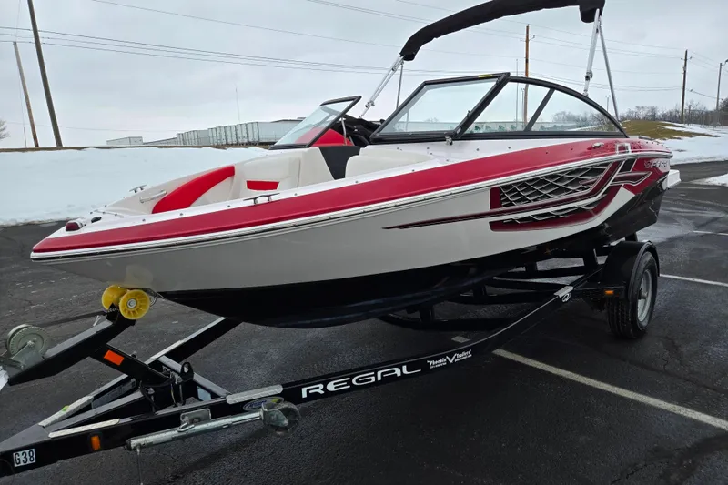 Slide: The Image of 2017 Regal 1900 ESX Bowrider on trailer, red and white design, parked on asphalt. - 5