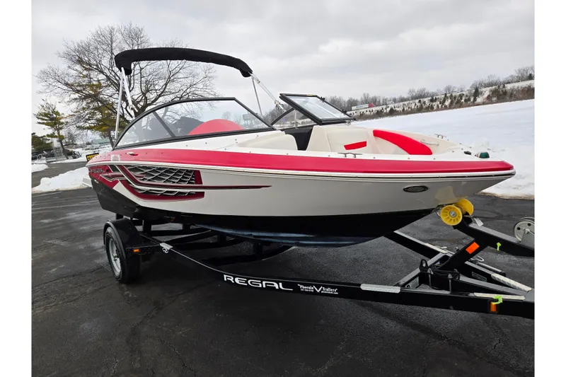 Slide: The Image of 2017 Regal 1900 ESX Bowrider on trailer, red and white design, parked on snowy pavement. - 8
