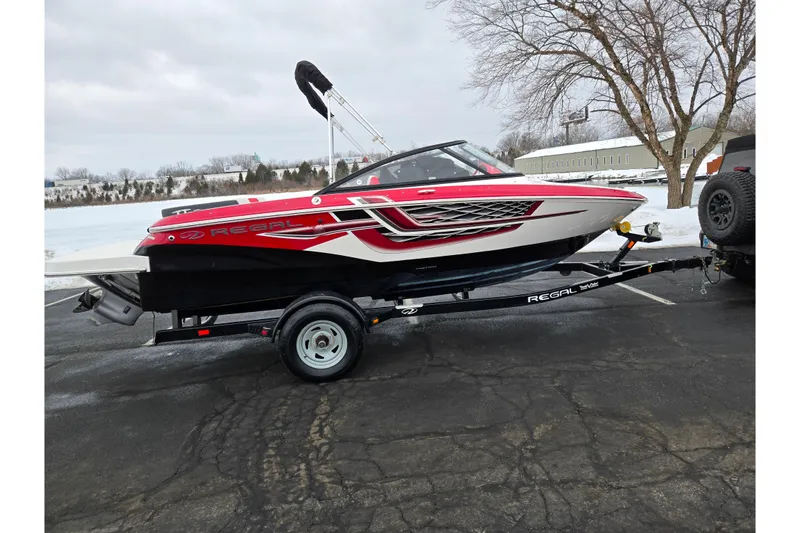 Slide: The Image of 2017 Regal 1900 ESX Bowrider on trailer, parked in snowy outdoor setting. - 9