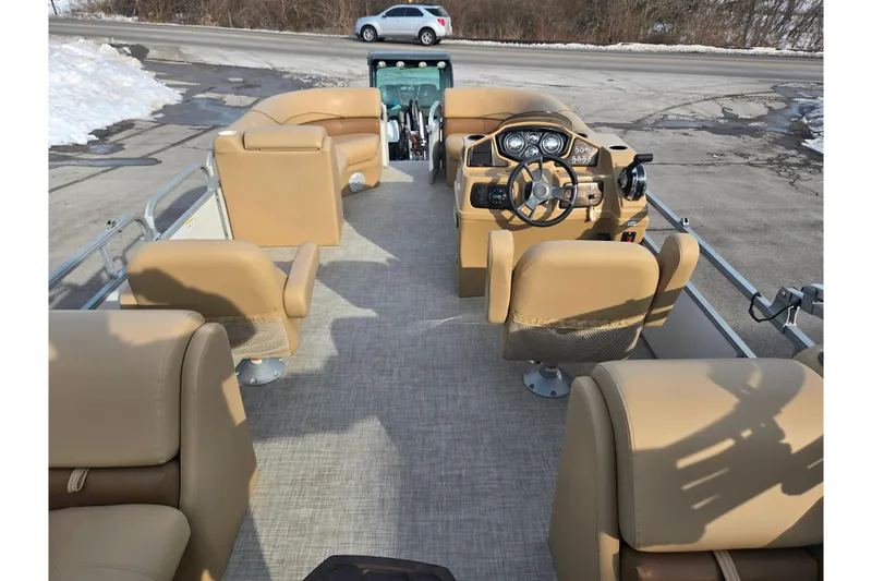 Slide: The Image of 2021 Lowe SS 230 WT pontoon boat interior with tan seating and modern dashboard. - 19