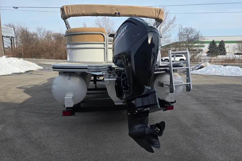 Slide: The Image of 2021 Lowe SS 230 WT pontoon boat with Mercury outboard motor, parked on snowy pavement. - 2