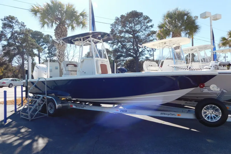 Slide: The Image of 2026 Pathfinder 2600 TRS boat on trailer, parked outdoors under palm trees. - 18