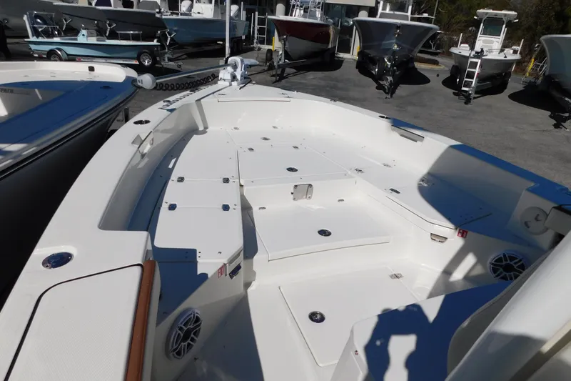 Slide: The Image of 2026 Pathfinder 2600 TRS boat deck, spacious layout, parked among other boats. - 27
