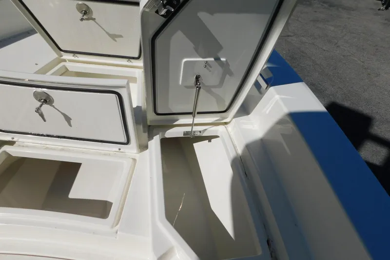 Slide: The Image of 2026 Pathfinder 2600 TRS boat storage compartments with secure locks and open hatches. - 36