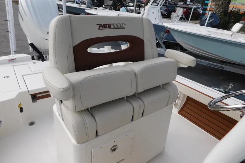 Slide: The Image of 2026 Pathfinder 2600 TRS boat seat with armrests and logo, docked in marina. - 4