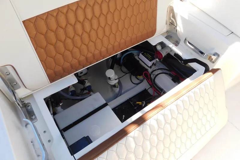 Slide: The Image of 2026 Pathfinder 2600 TRS boat storage compartment with electrical components and honeycomb-patterned upholstery. - 47