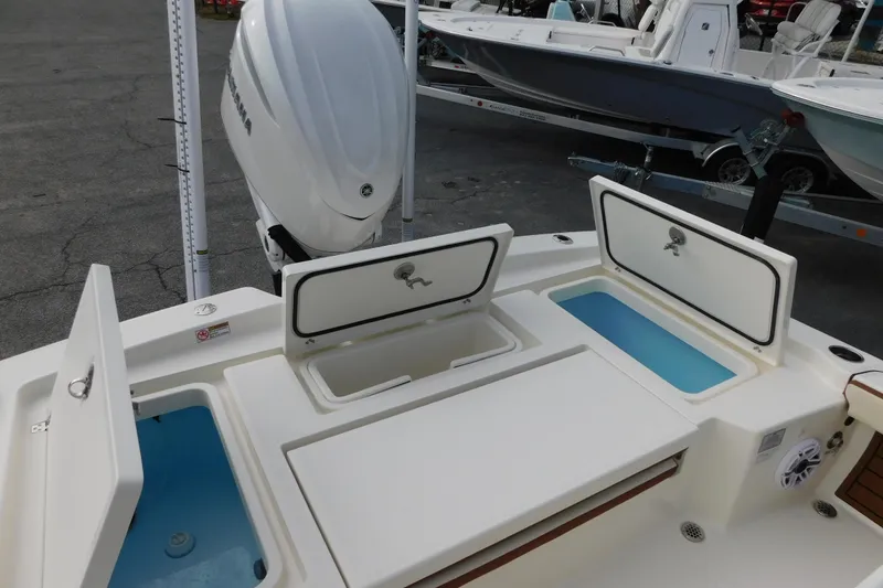 Slide: The Image of 2026 Pathfinder 2600 TRS boat with open storage compartments and outboard motor. - 8